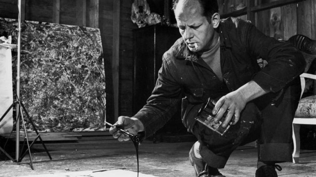 Jackson Pollock al lavoro utilizzando la sua riconoscibile tecnica.