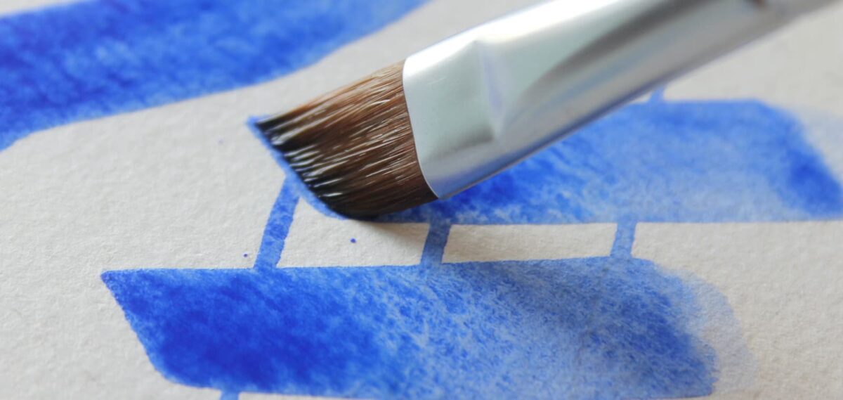 Pennello che traccia colore su foglio