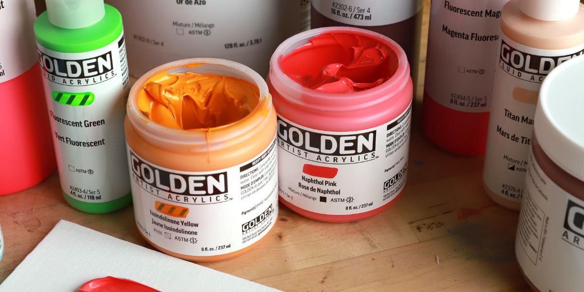 Tubetti di colori acrilici Golden Heavy Body con campioni di colore denso e pennellate materiche.