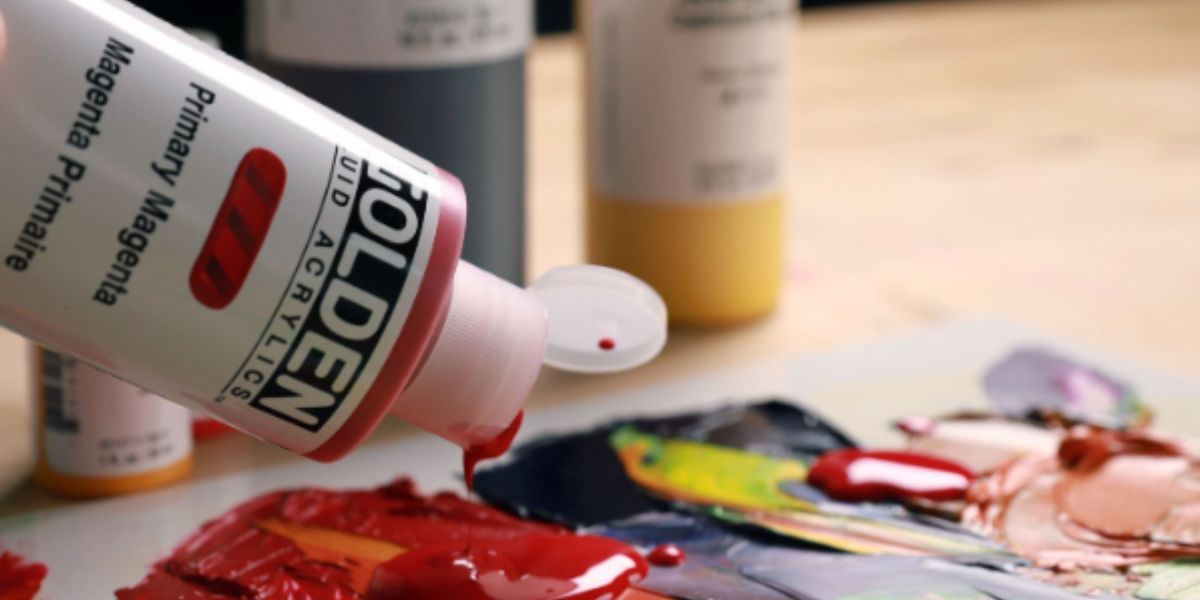 Flaconi di colori acrilici Golden Fluid con campioni di colore stesi in velature e colate su carta e tela.